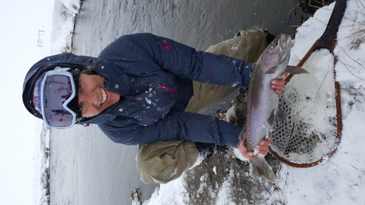 Large rainbow trout comes to hand a new Mammoth Lakes California while fishing in a blizzard
