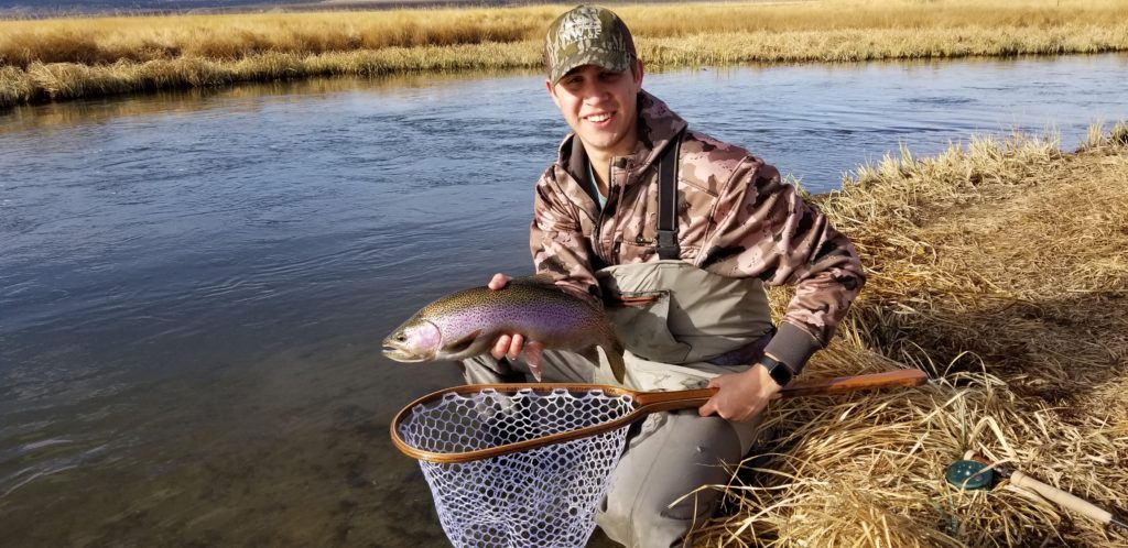 Angler hold up a large rainbow trout