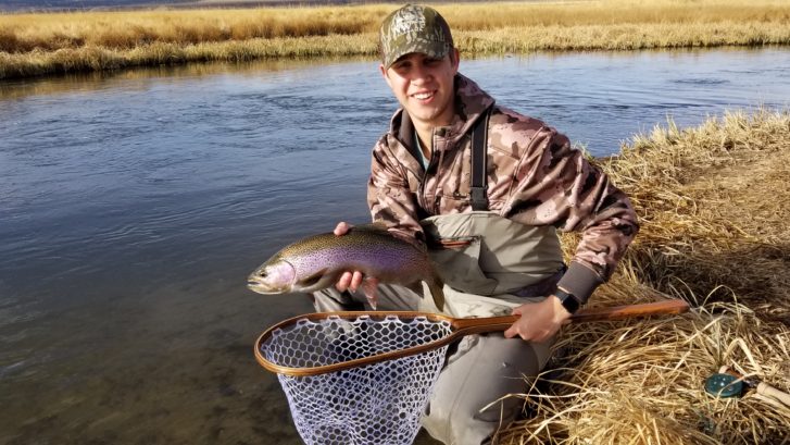 Angler hold up a large rainbow trout