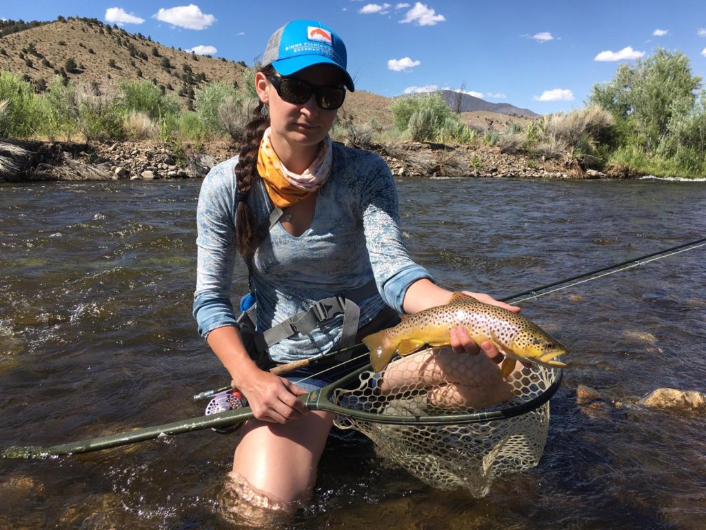Young woman holds up a beautiful brown trout from the East Walker River