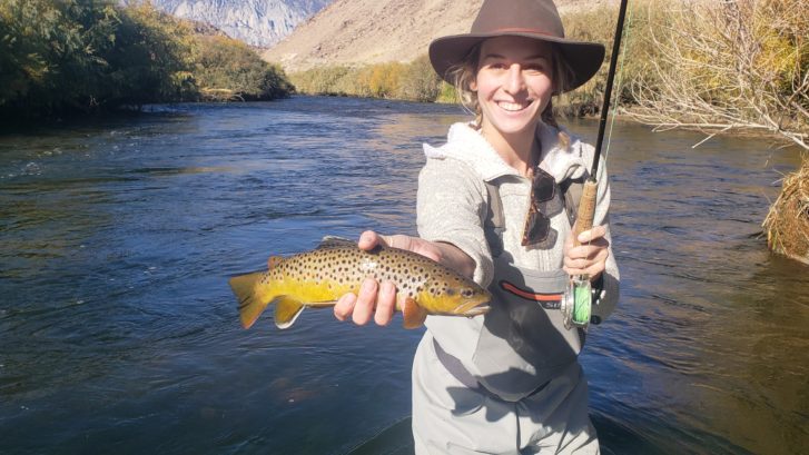 Young Girl holds up a Brown Trout while Fly Fishing on the Lower Owens River near Bishop California