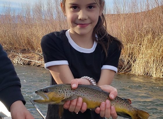 Young girl holds a beautiful brown above the water