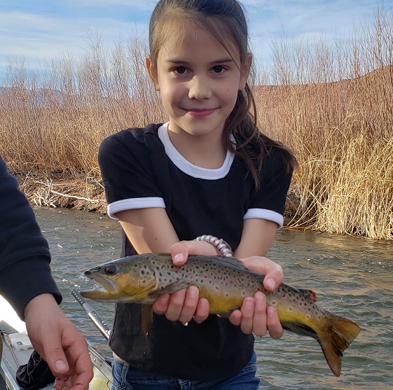 Young girl holds a beautiful brown above the water