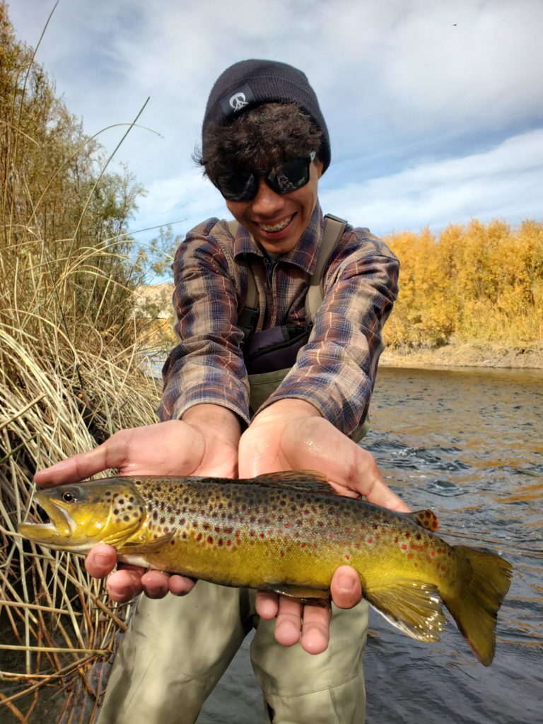 lower owens river brown trout held up by a lucky young angler out of Bishop California.