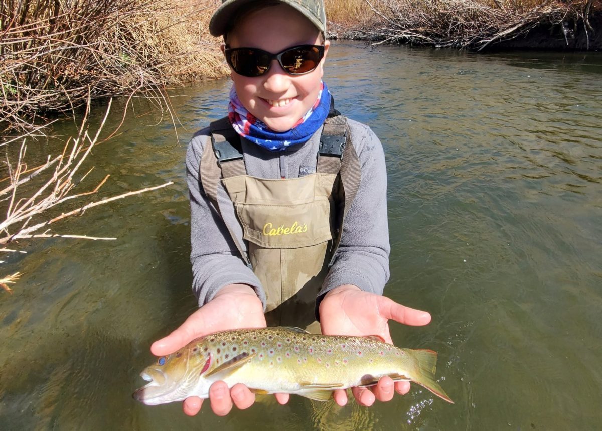 young boy hold up a brown trout on the Lower Owens River near Bishop California