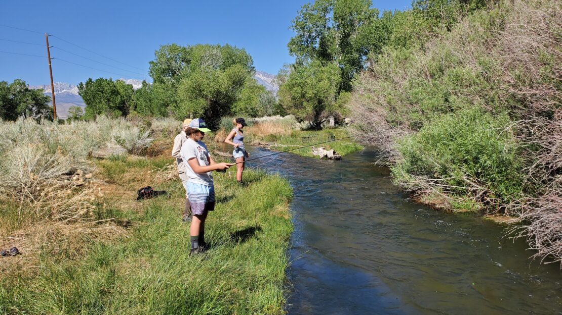 Three people Enjoying the Creek fishing of bishop california