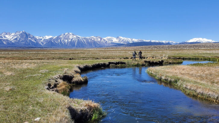 Two anglers stand on the banks of the upper owens river near mammoth lakes california