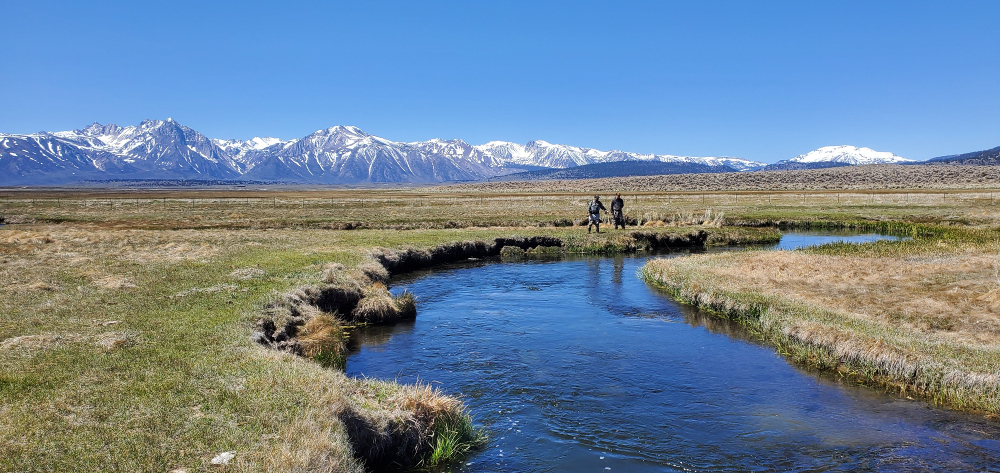 Two anglers stand on the banks of the upper owens river near mammoth lakes california