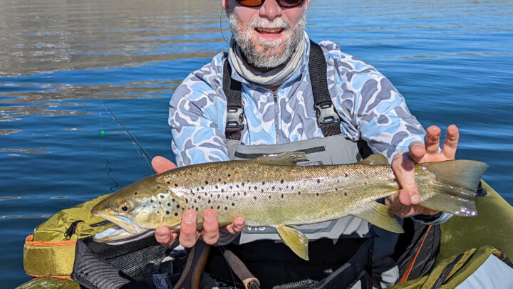 large brown trout on crowley lake held by an angler in a float tube below mammoth lakes ca