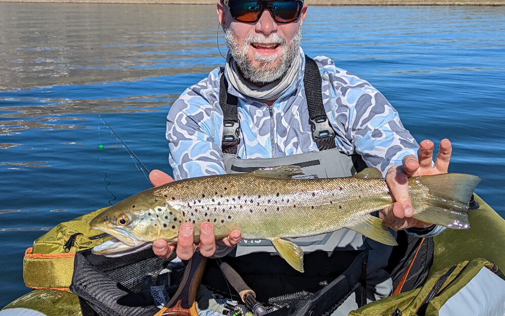 large brown trout on crowley lake held by an angler in a float tube below mammoth lakes ca