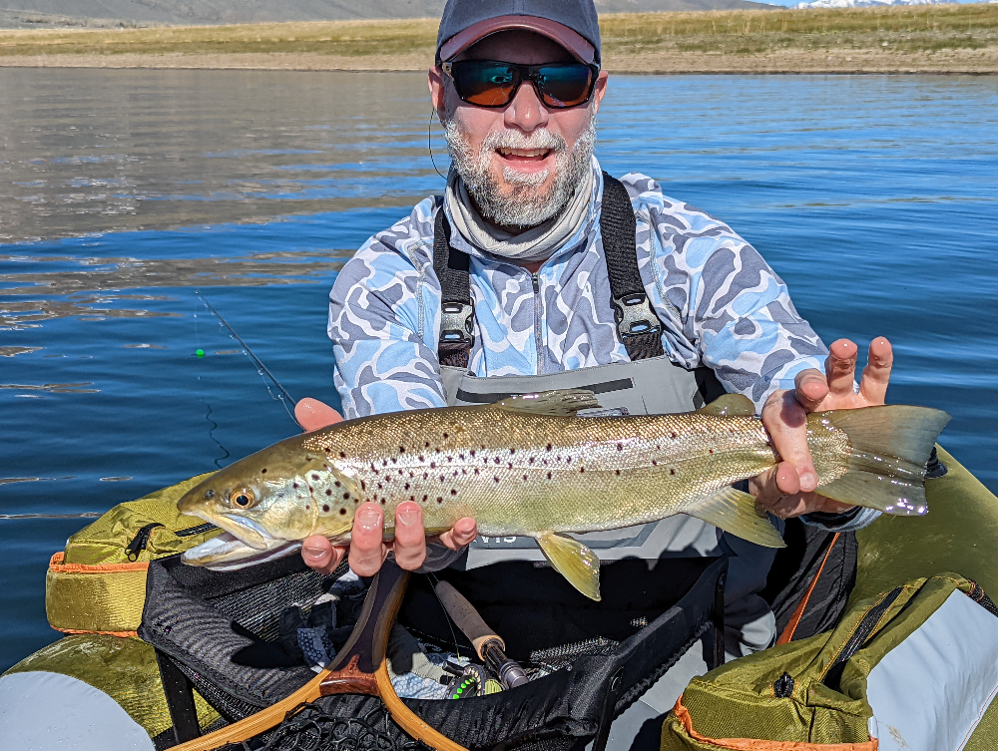 large brown trout on crowley lake held by an angler in a float tube below mammoth lakes ca